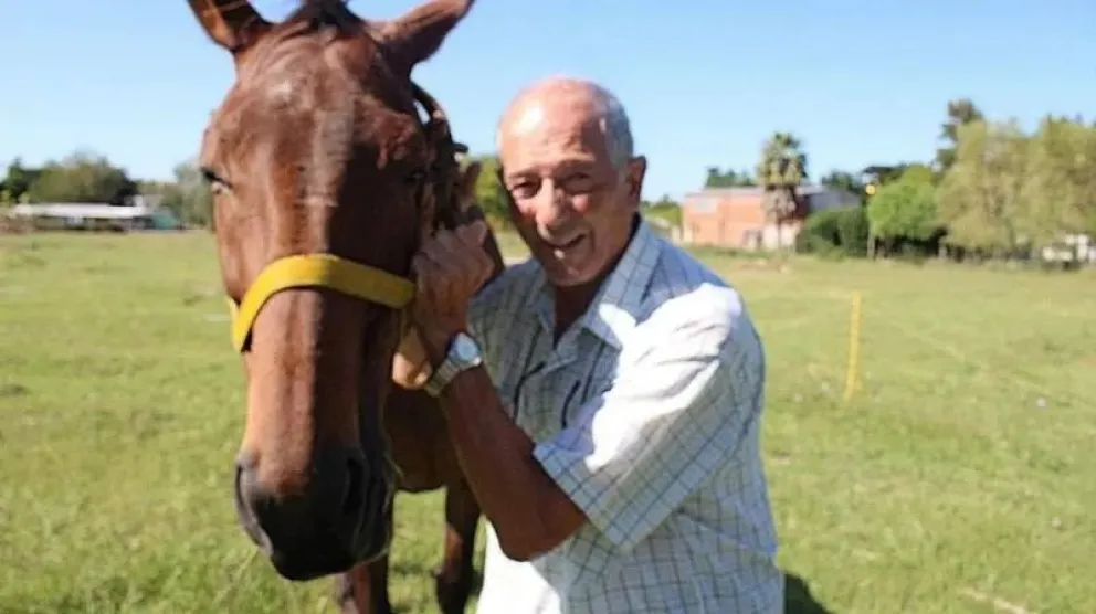 El padre Horacio Fasce en un entorno rural, reflejando su vínculo con la naturaleza y su pasión por la equitación.